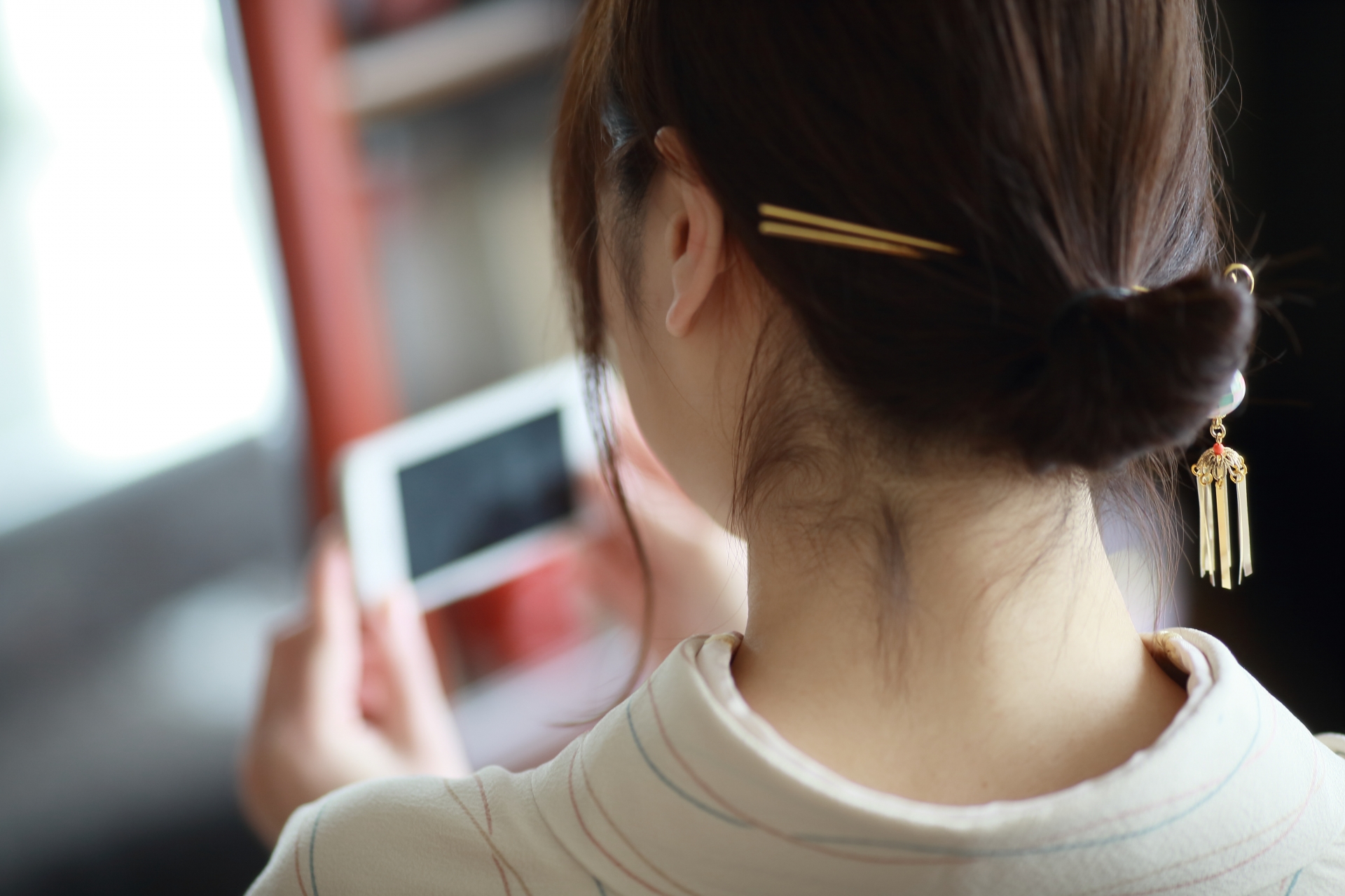 髪留めをつけた女性が旅館のフロントでお客様を迎えている。