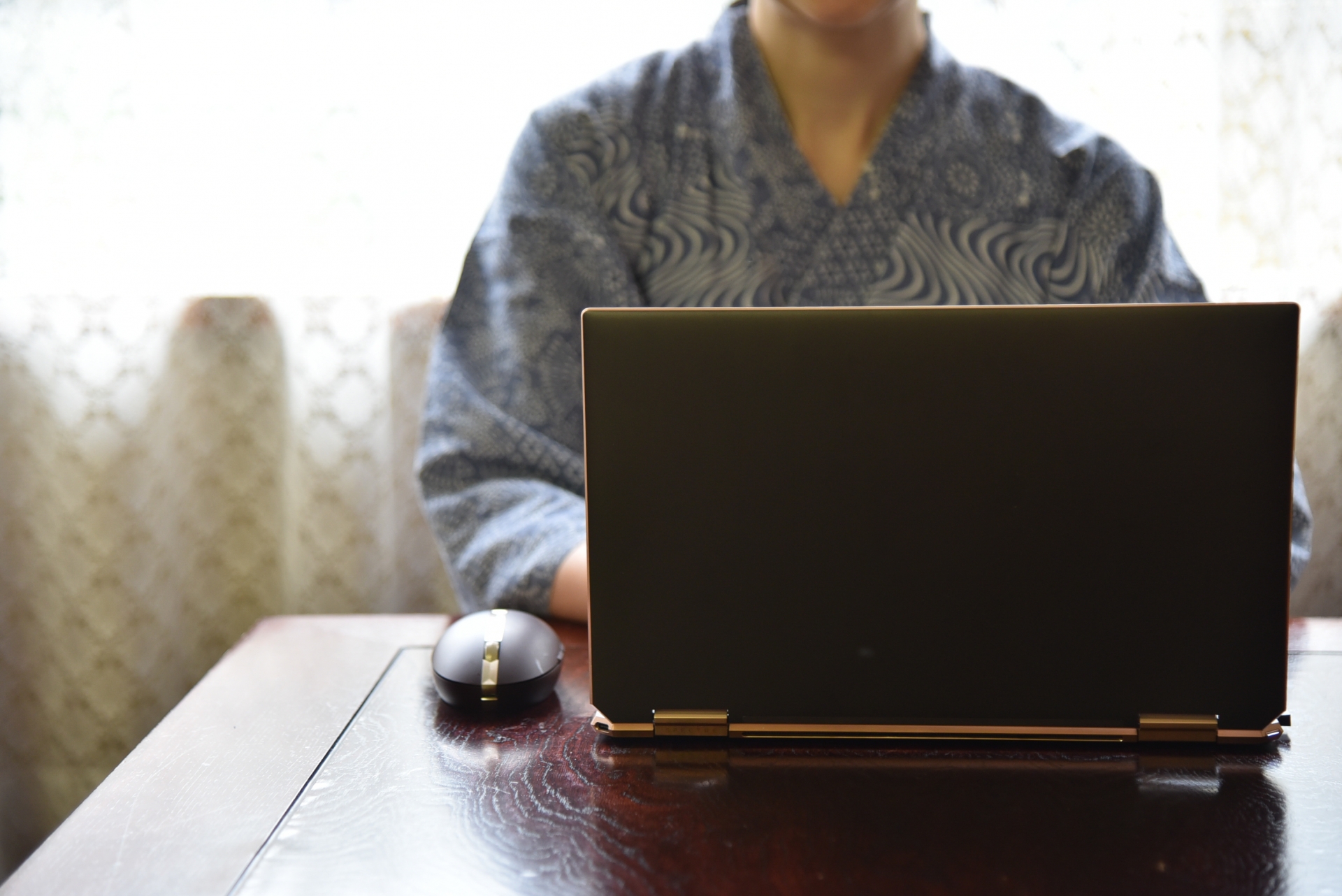 ノートパソコンを操作している男性がデスクに座っている様子を示しています