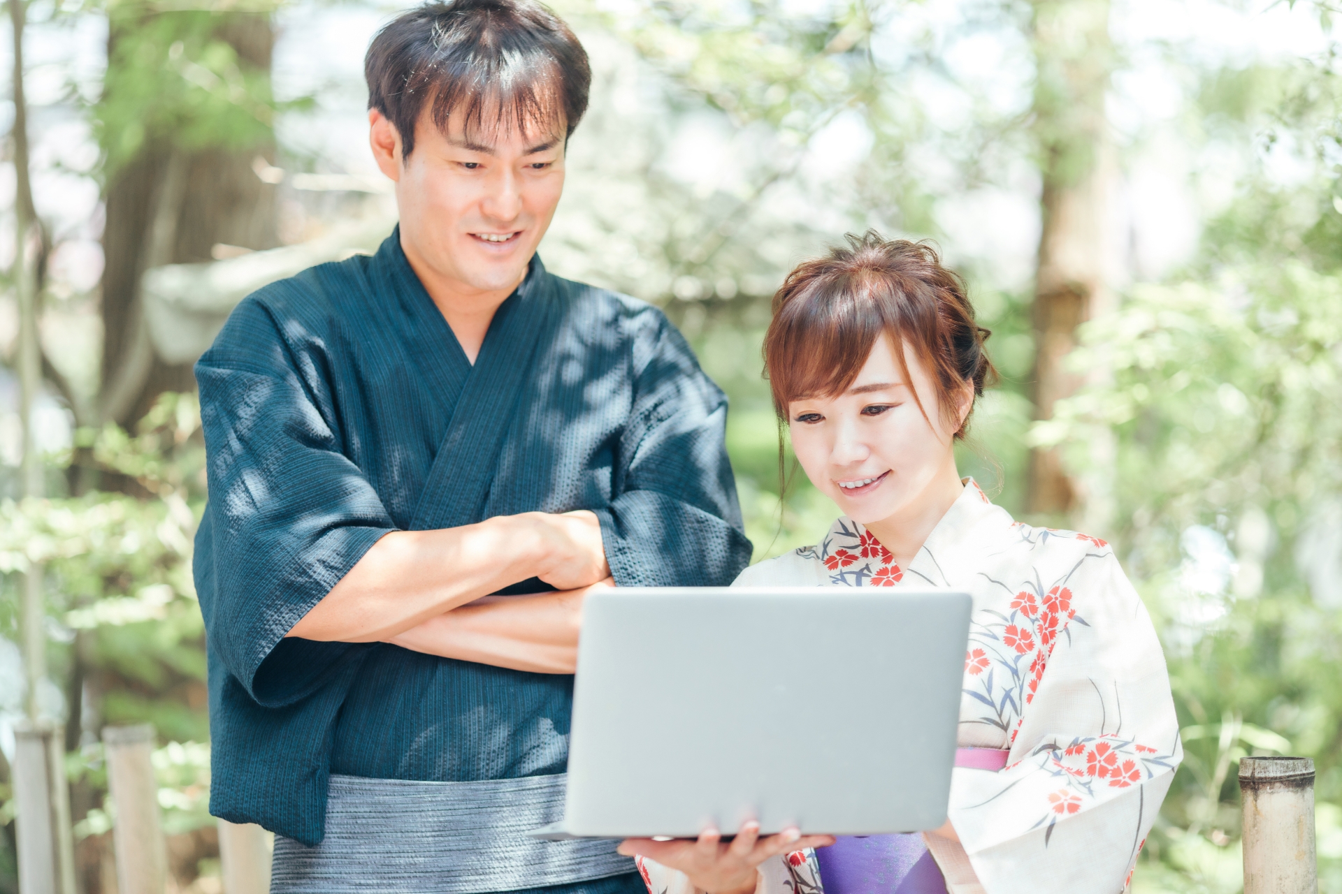  浴衣姿の男性と女性がノートパソコンを見ている様子。