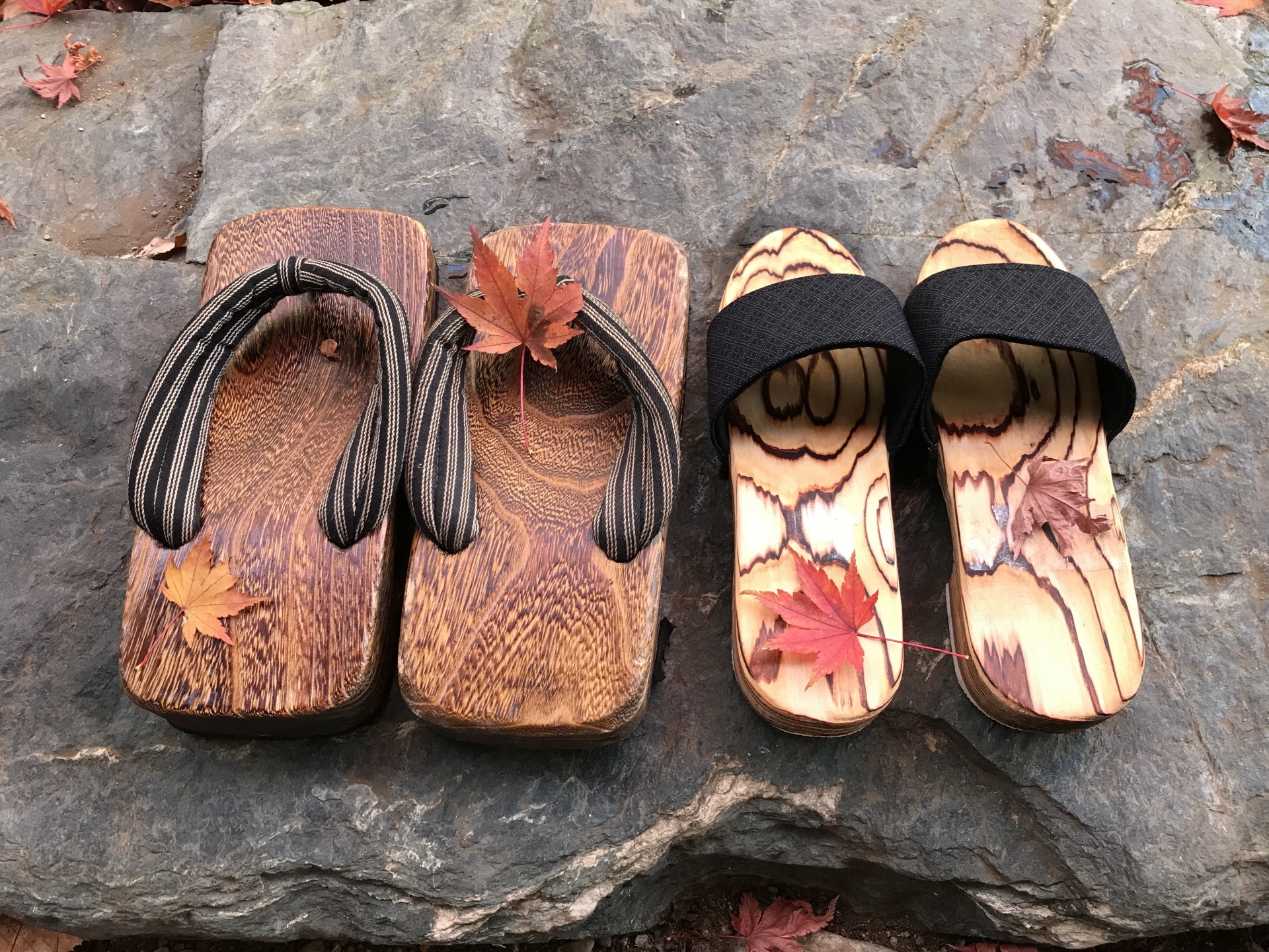 旅館の雰囲気を感じさせる、葉が乗った二つの木製下駄の画像です。